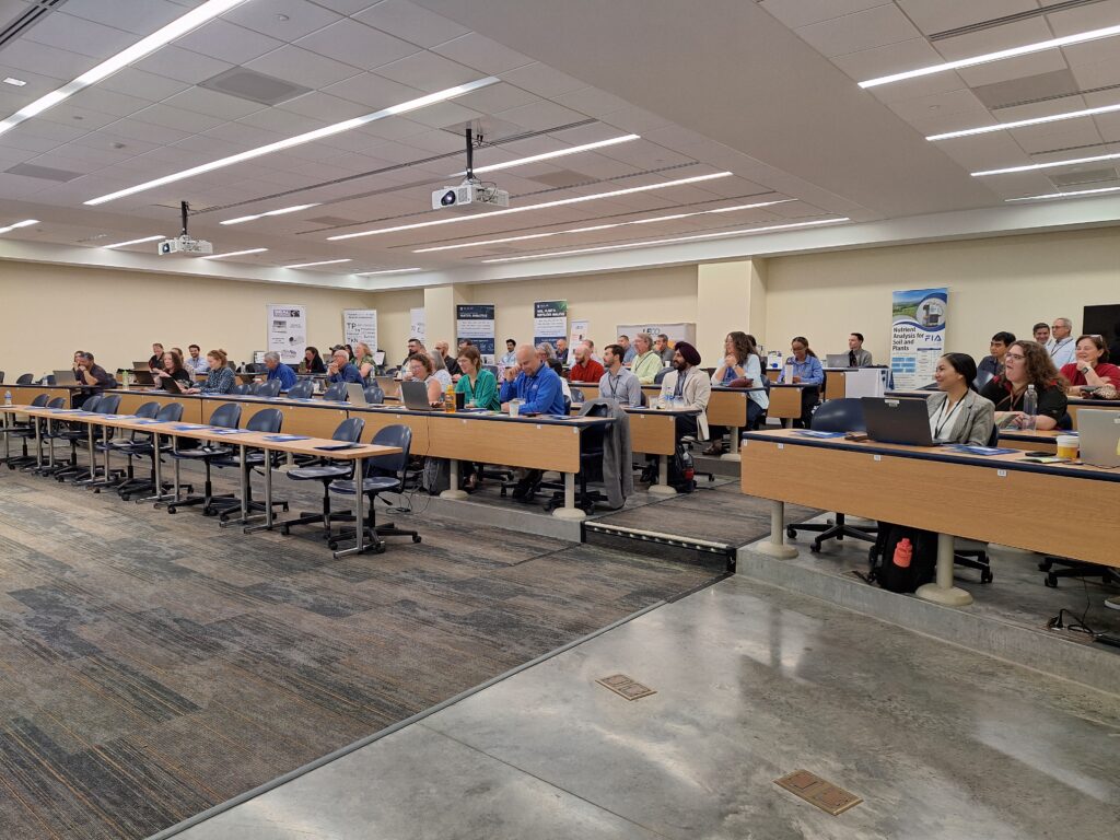 People sitting at tables with presentation on going.
