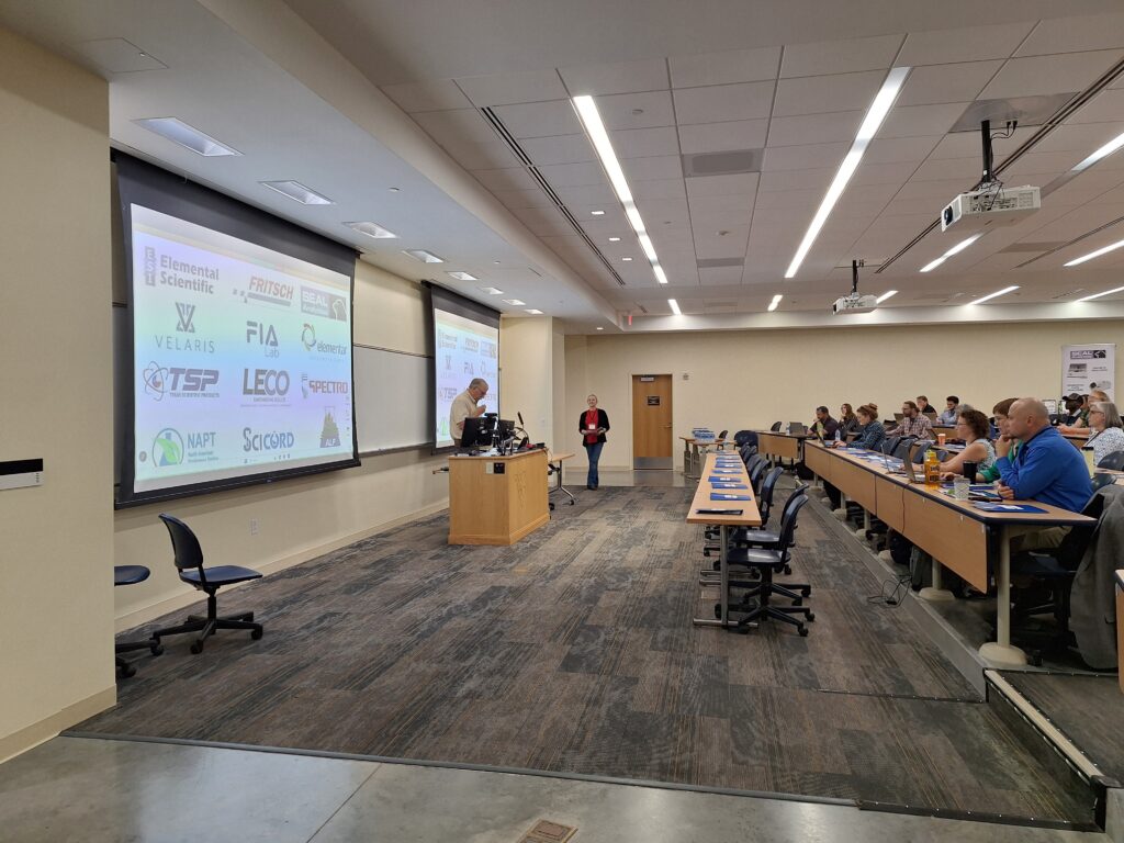 People sitting at tables with presentation on going.