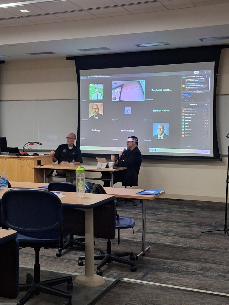 People sitting at tables with presentation on going.
