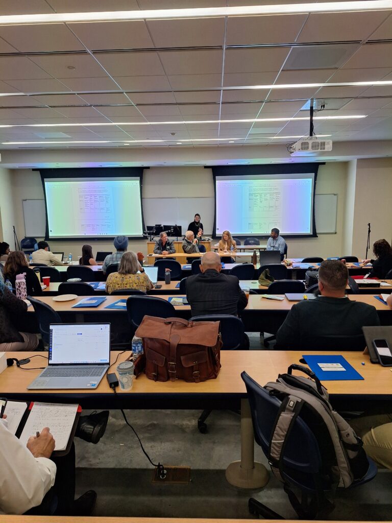 People sitting at tables with presentation on going.